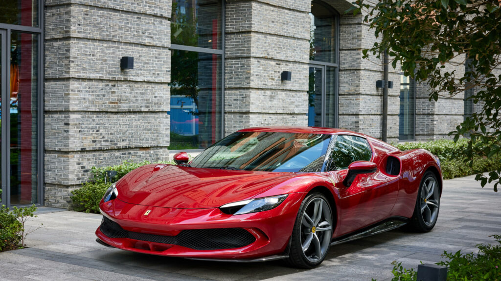 Revving Up in Style: 4K Laptop Car Background Featuring a Striking Red Ferrari 296 GTB Against a Spectacular Brick Wall Backdrop Wallpaper