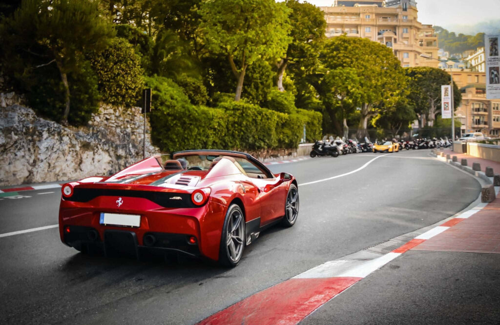 The Bracing Velocity: A Dynamic Snapshot of the Red Ferrari 458 Speciale Roaring through a Breathtaking Scenic Route Wallpaper