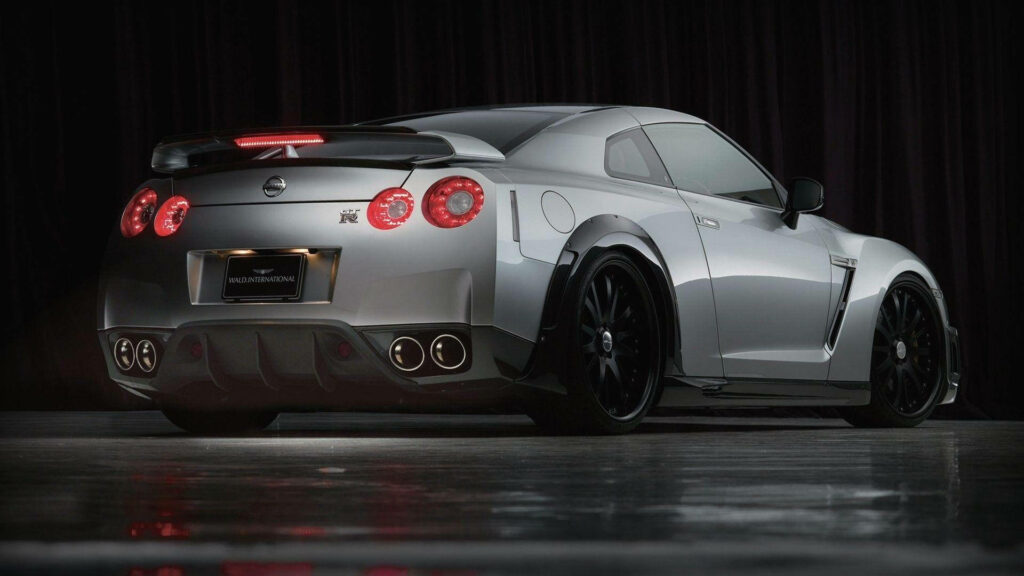 Silver Beauty: Captivating Nissan GT R35 Dominating the Road with Fiery Red Brake Lights Wallpaper