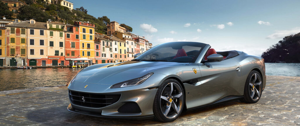 Gray Ferrari Near Lake and Colorful Buildings Background Wallpaper