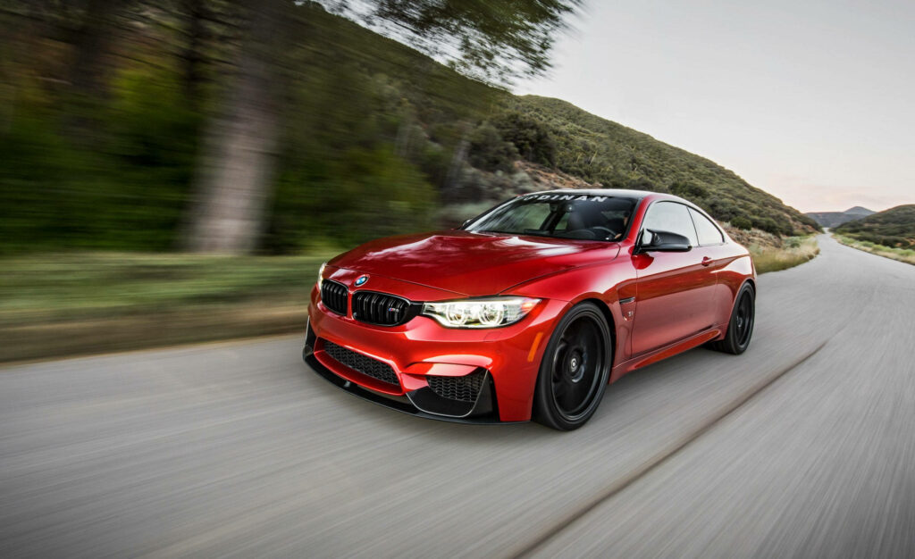 Lightning on Wheels: Capturing the Thrill of a Speeding Red BMW M4 on a Sunny Day Wallpaper