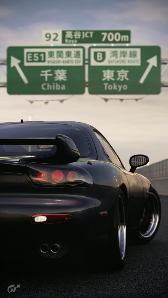 Speeding through the Tokyo-Chiba Expressway in a Sleek Black Mazda Rx-7 Wallpaper
