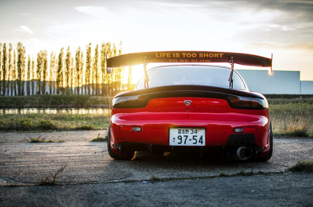 Rev Up Your Life: A Red Mazda RX-7 Racing Into the Sunset Wallpaper