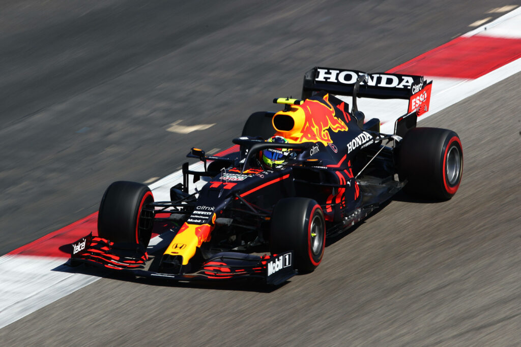 Speeding Ahead: Sergio Perez Racing in his F1 Car with Red Bull's Emblem at Full Throttle Wallpaper