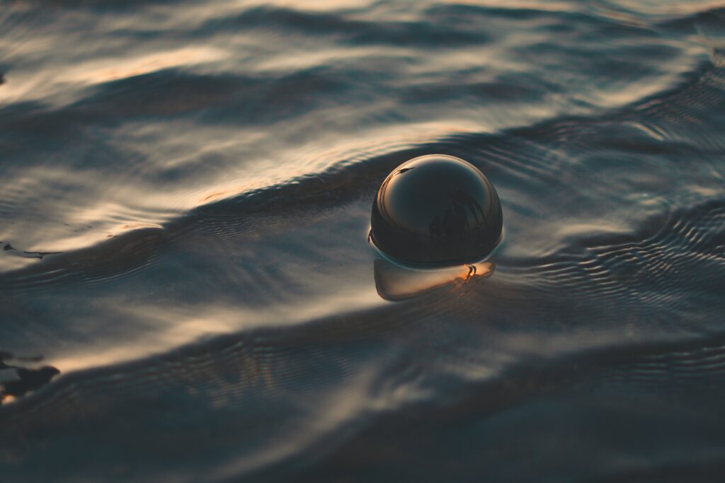 Spherical Ball on Rippling Water: Serene Wallpaper Background