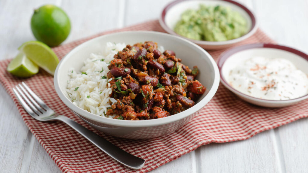 Vibrant Chili Con Carne Wallpaper: Spicy Meal with Rice & Guacamole
