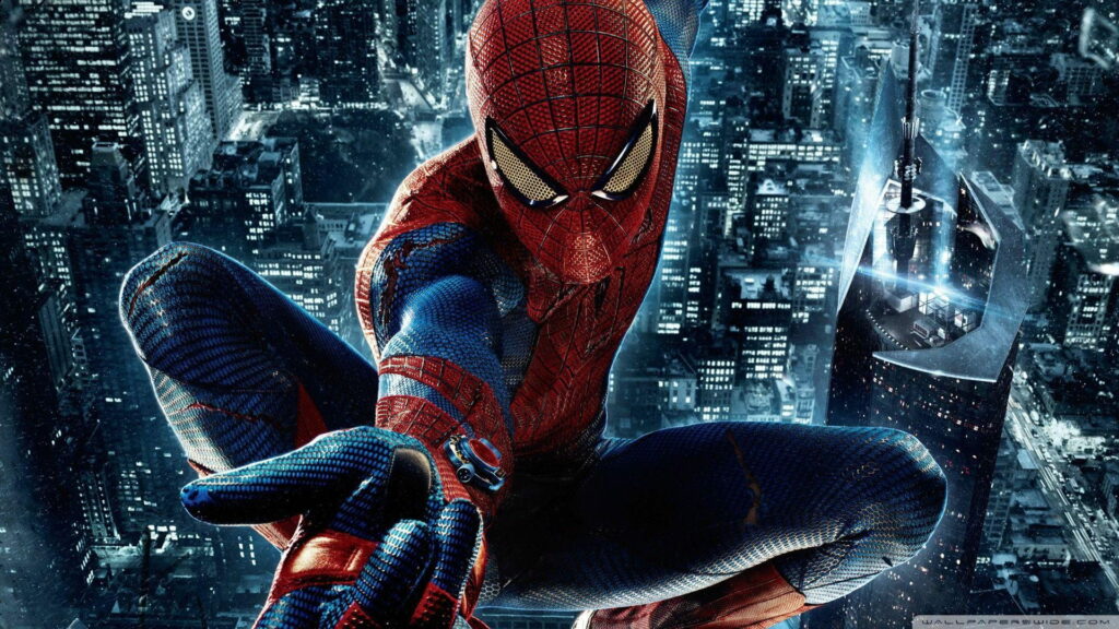 Spiderman in red-blue suit perched above vibrant night cityscape with glowing skyscrapers wallpaper