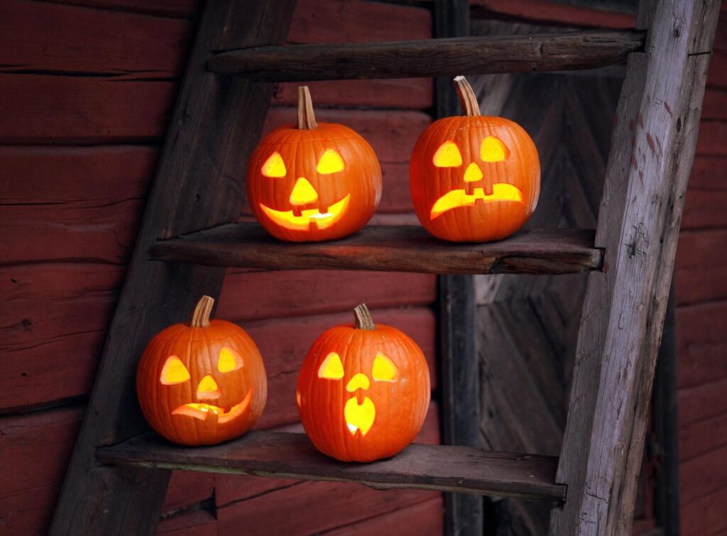 Spooky Halloween Wallpaper: Carved Pumpkins on Rustic Ladder