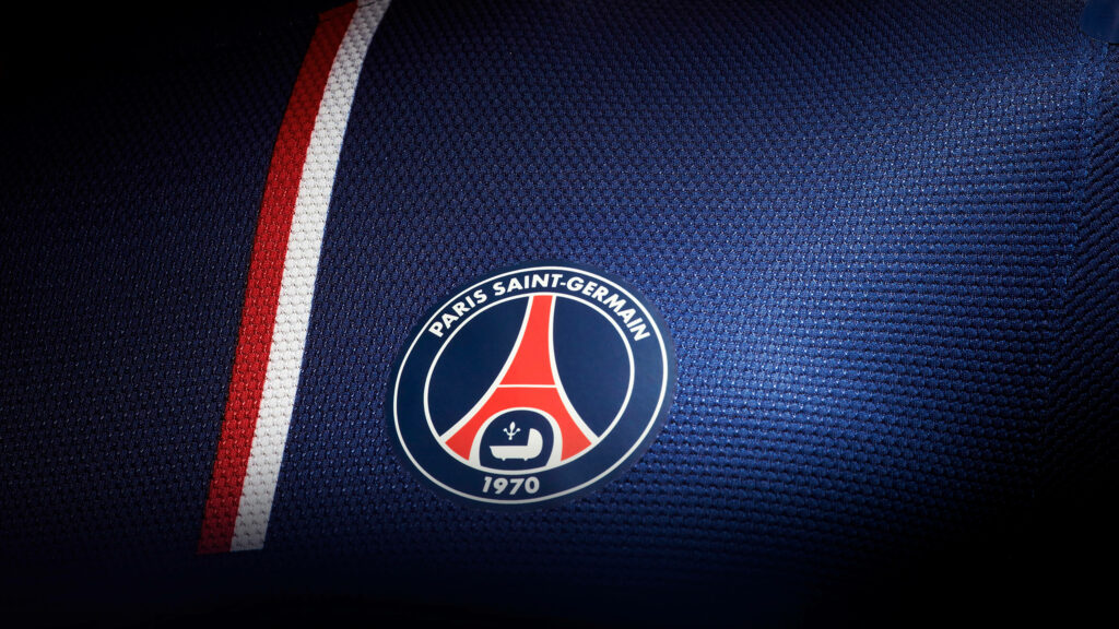 PSG Powerplay: A Bold Wallpaper Featuring the Iconic Logo On the Chest of a Dark Blue Jersey