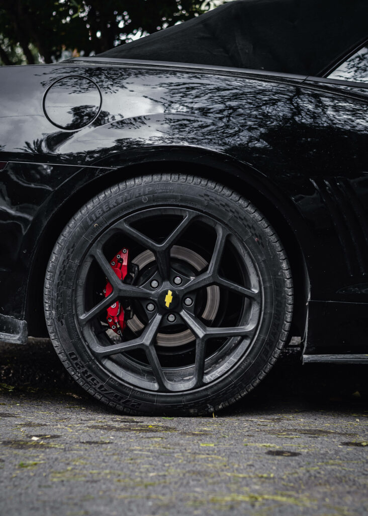 Sporty Black Chevrolet Rim Wallpaper with Bold Yellow Emblem