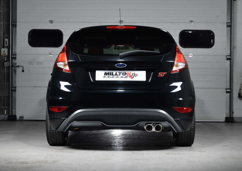 Rear view of black Ford Fiesta ST with Milltek exhaust parked indoors sporty car wallpaper