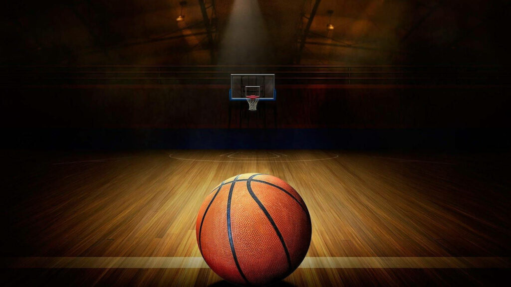 Spotlight On Sports: High Definition Image of Basketball Under Illumination With Hoop in Background Wallpaper