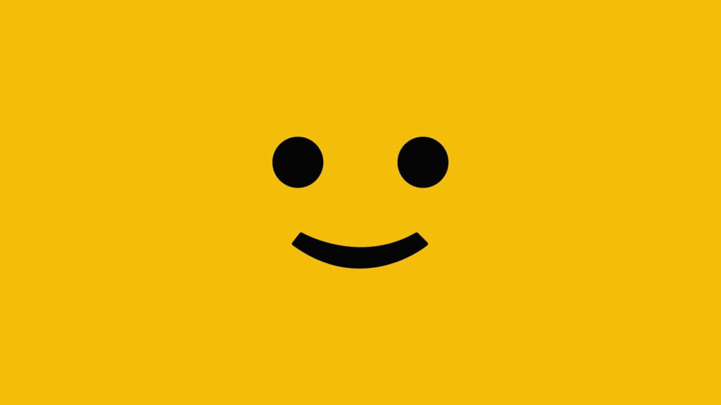 Minimalist smiley face wallpaper with black eyes on vibrant yellow background for positivity