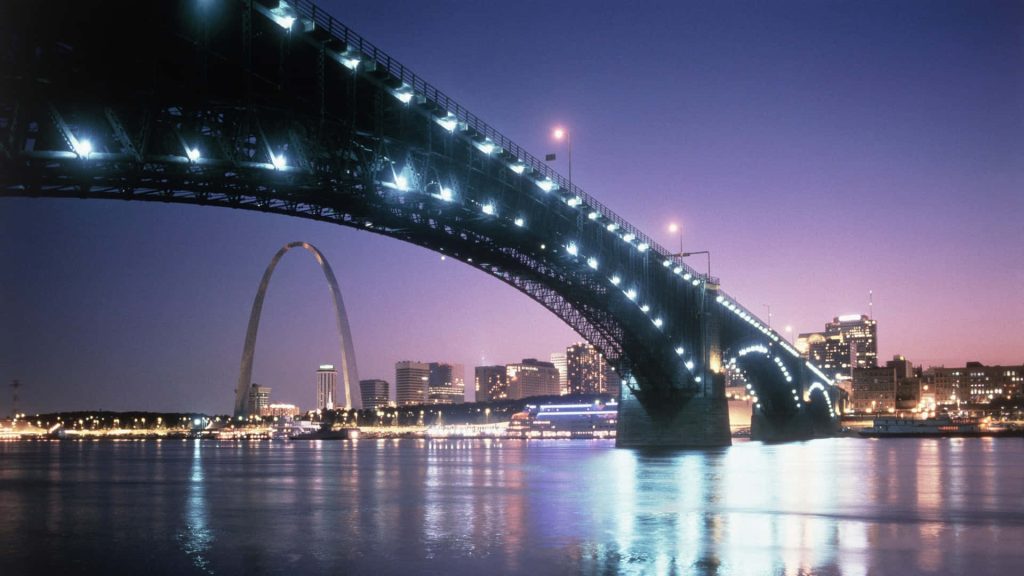 Twilight view of St Louis skyline with illuminated Eads Bridge Gateway Arch and Mississippi River Wallpaper