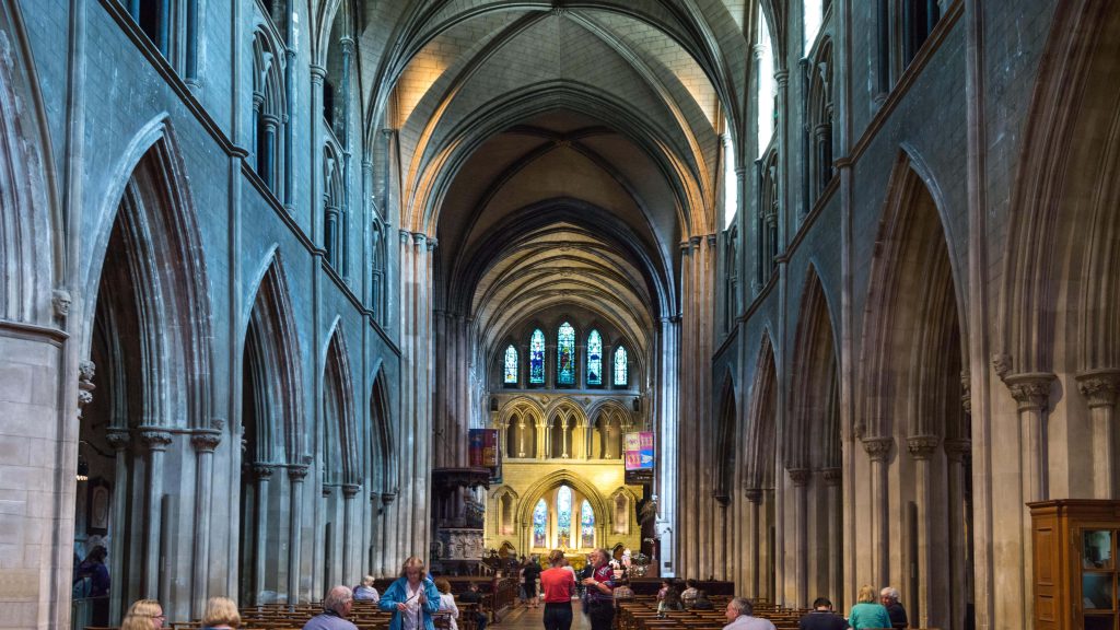 St Patricks Cathedral Dublin Gothic vaulted ceilings stone pillars stained glass windows interior Wallpaper