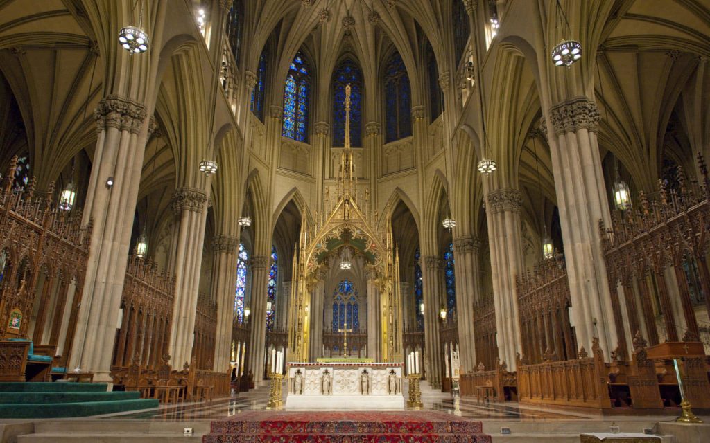 Interior view of St Patricks Cathedral NYC with ornate altar stained glass and vaulted ceilings Wallpaper