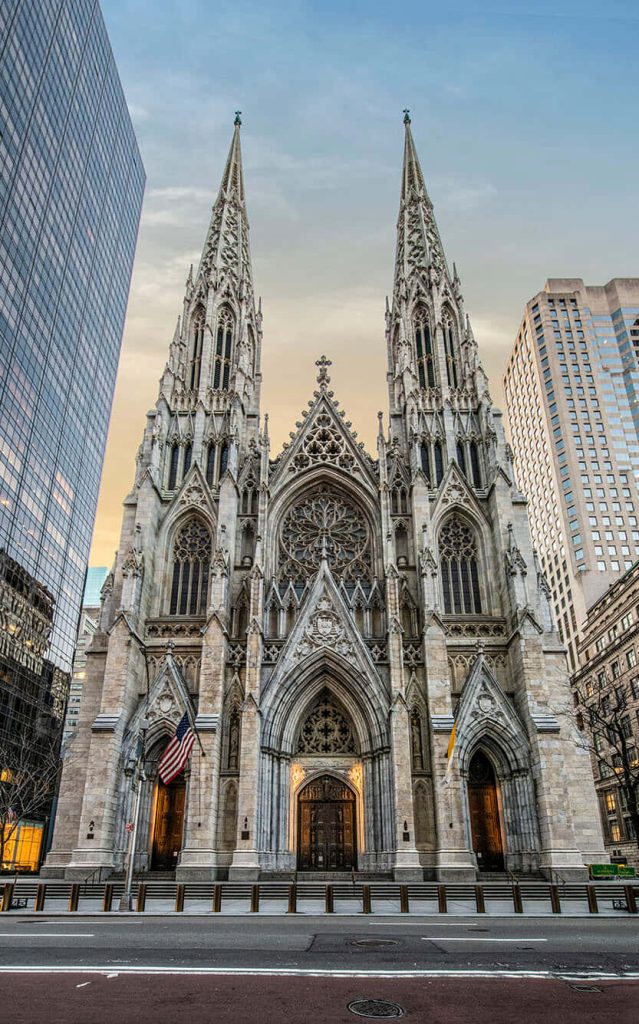 St Patrick's Cathedral NYC Neo Gothic spires against skyscrapers at golden hour wallpaper background