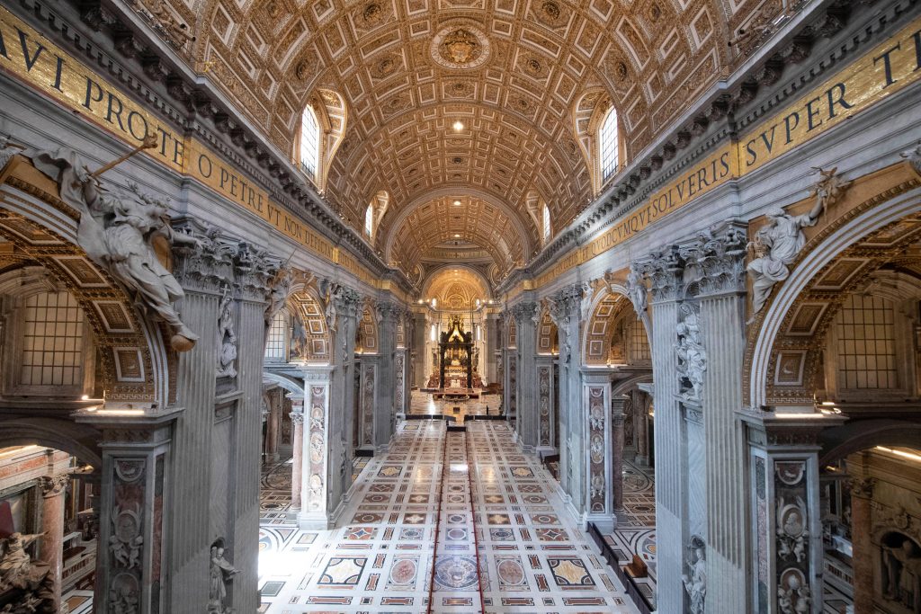 Interior view of St Peters Basilica nave Vatican with golden ceiling and marble floors wallpaper