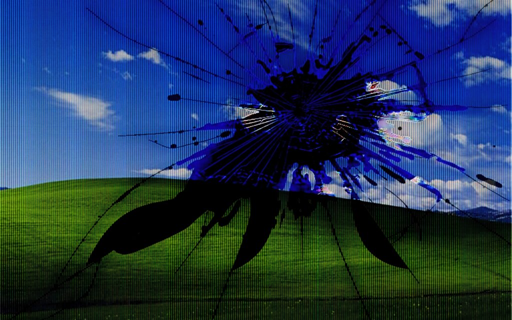 Broken screen effect over rolling green hills and blue sky surreal cracked wallpaper background