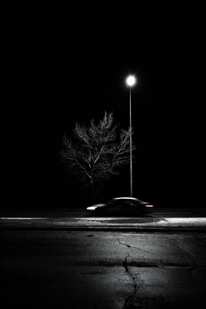 Stark Leafless Tree at Night: Black & White Street Scene Wallpaper