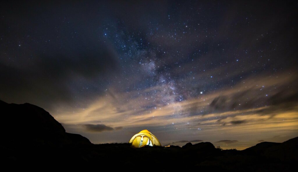 Starry Night Camping: A HD Wallpaper of a Tent beneath a Twinkling Sky