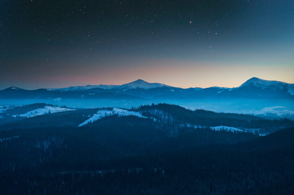 Nightscape's Heavenly Canopy: Serene Blue Landscape in Starry Evening Sky, an HD Wallpaper Background