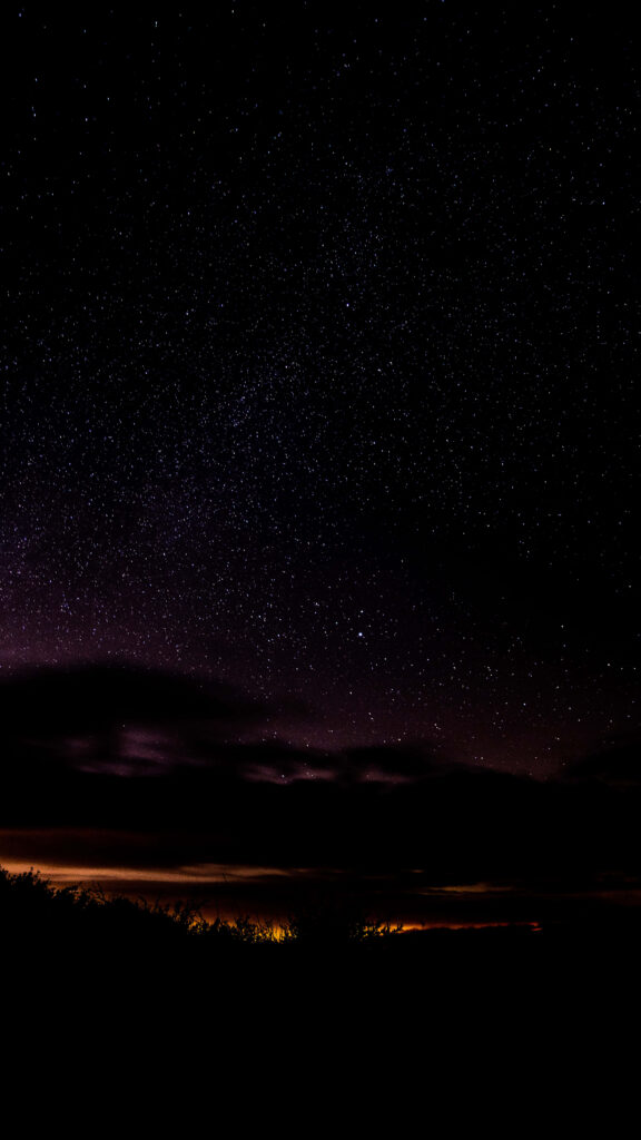 Starry night wallpaper with silhouetted horizon, evoking mystery and adventure.