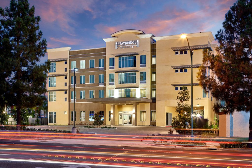 Staybridge Suites Anaheim hotel exterior at twilight with warm lighting and vibrant light trails Wallpaper