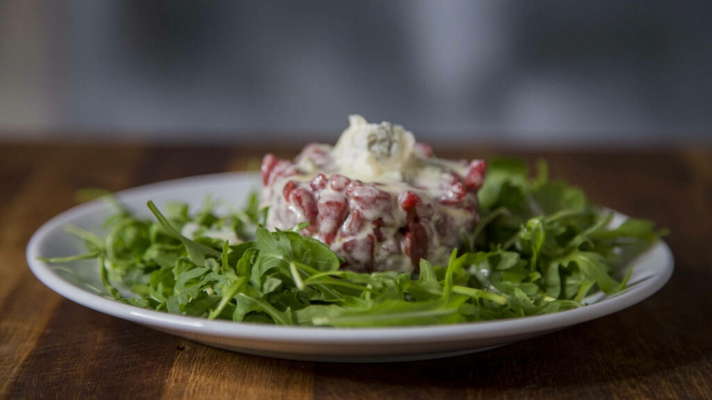Stylish Steak Tartare Wallpaper with Arugula on Wooden Table