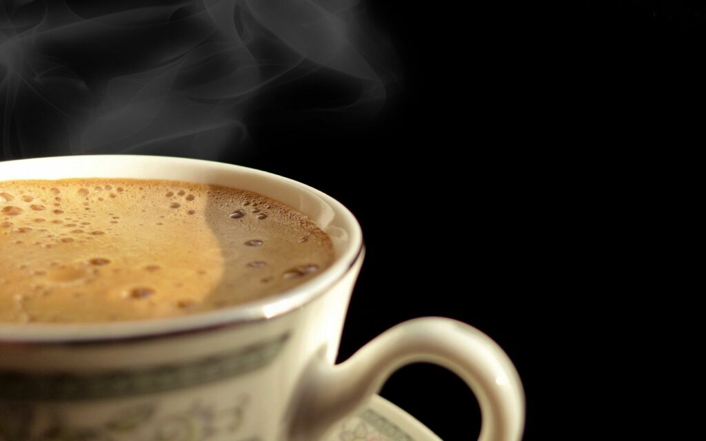 Steaming Coffee Cup Wallpaper: Warm & Inviting Black Background