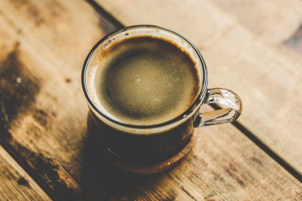 Steaming Coffee Cup on Rustic Wood: Aromatic Wallpaper Background