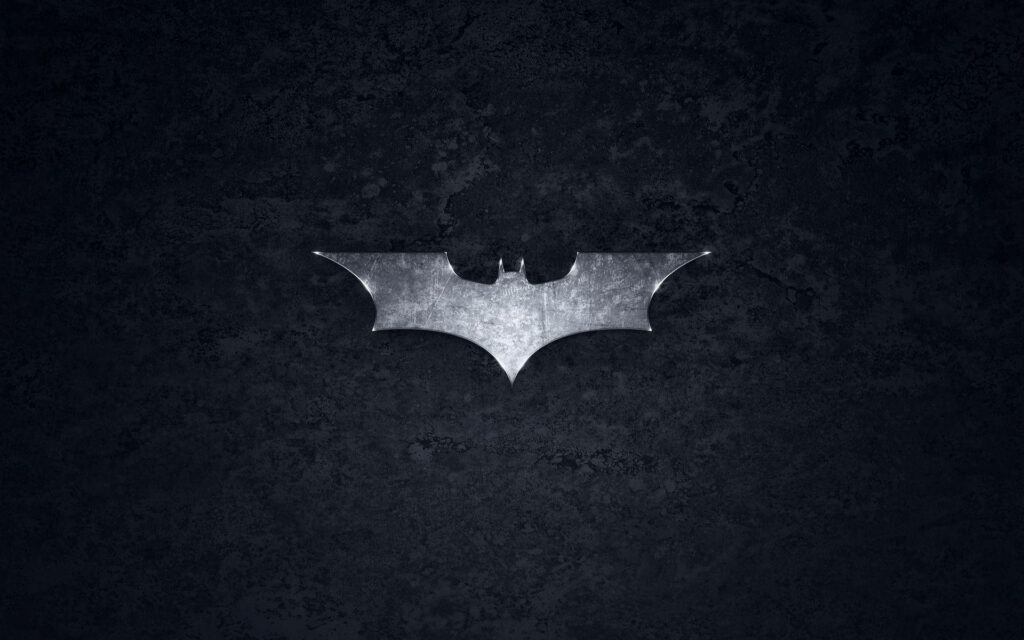The Dark Knight Awakens: An Impressive Steel Symbol of Batman on a Stylish Black Logo Wallpaper