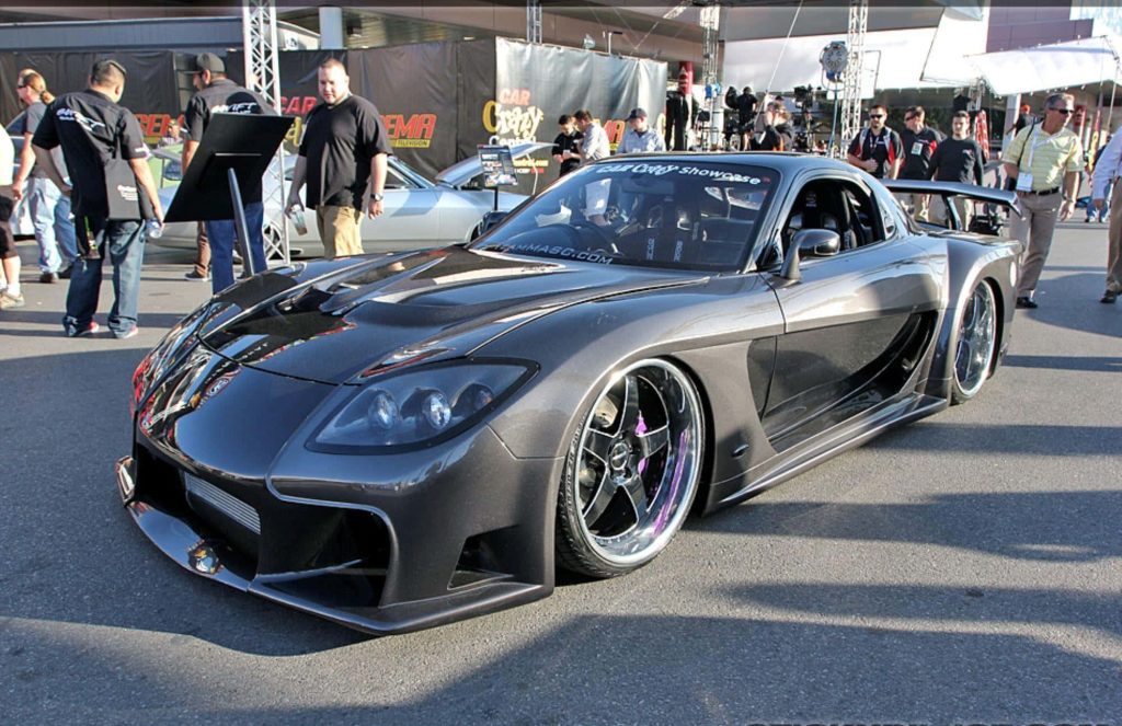 Steel-gray Mazda RX-7 FD with widebody kit and deep-dish wheels at outdoor car event wallpaper