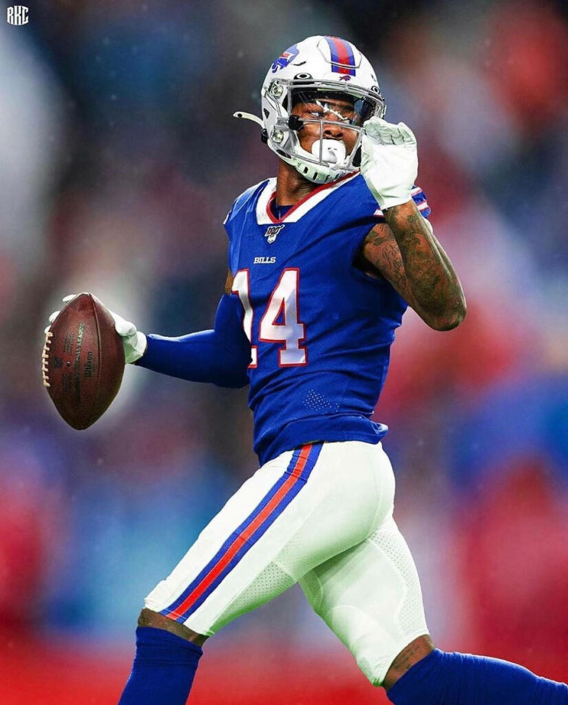 Stefon Diggs in blue Buffalo Bills uniform sprinting with blurred stadium background wallpaper