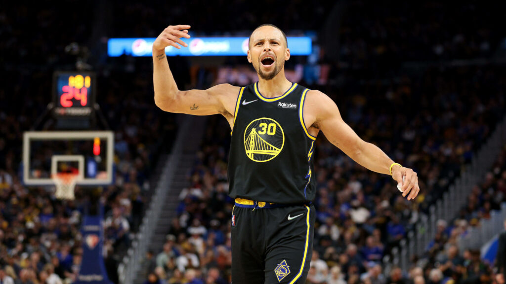 Rising Above: Steph Curry's One-Handed Triumph (Wallpaper)