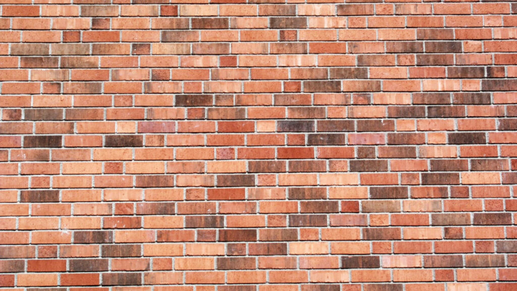 A Contemporary Display of Brown and Orange Textured Bricks: A Unique Brick Wall Background Wallpaper
