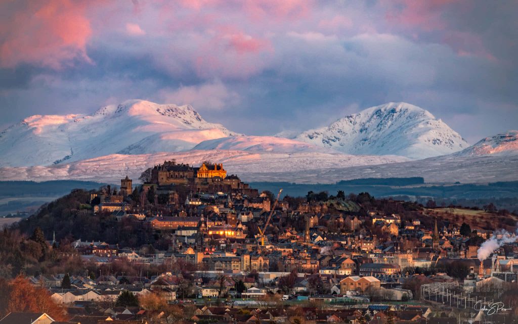 Stirling Castle at sunset with snow-capped mountains and pastel sky Scotland landscape wallpaper