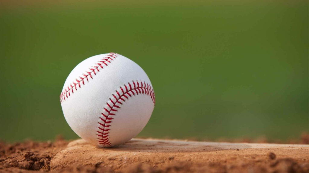 Softball Serenity: Beautiful White Ball Resting on a Stone Wallpaper