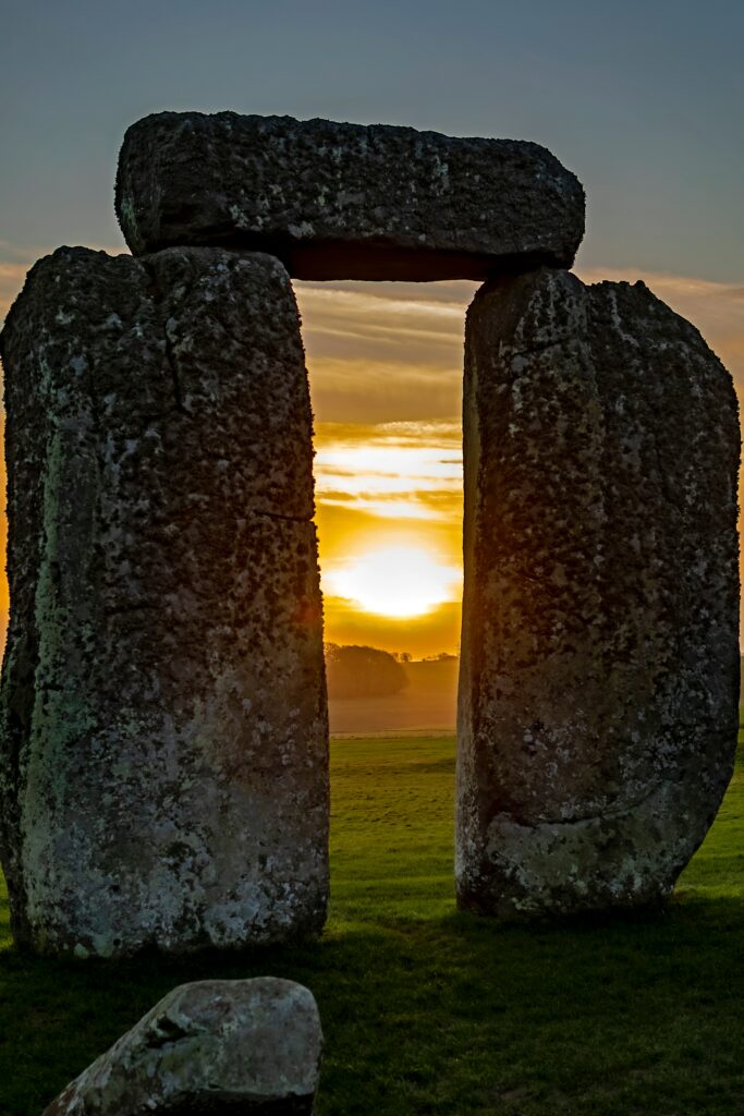 Stonehenge megaliths at sunset with golden light highlighting ancient weathered stones Wallpaper