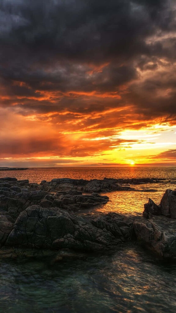 Majestic Coastal Serenity: Stormy Sunset Paints Malibu's Seaside Canvas Wallpaper