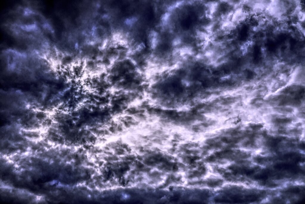 Dramatic stormy sky wallpaper with dense textured clouds deep blue and purple moody atmosphere