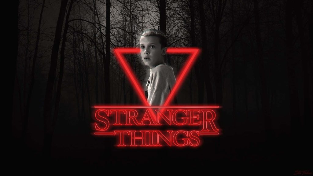 Stranger Things Eleven with glowing red neon triangle and logo in dark forest wallpaper