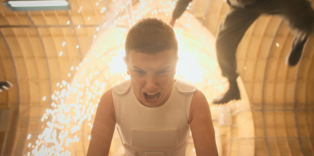 Eleven's Enigmatic World: A Captivating HD Wallpaper of Millie Bobby Brown from the Acclaimed TV Show 'Stranger Things'