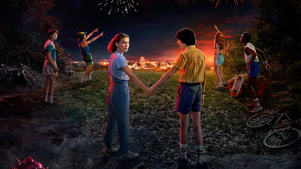 Stranger Things wallpaper Eleven Mike holding hands with friends on hill night sky fireworks carnival