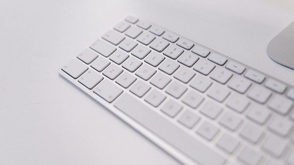 Simplicity Unveiled: Wireless Mac Keyboard Gracefully on White Canvas Wallpaper
