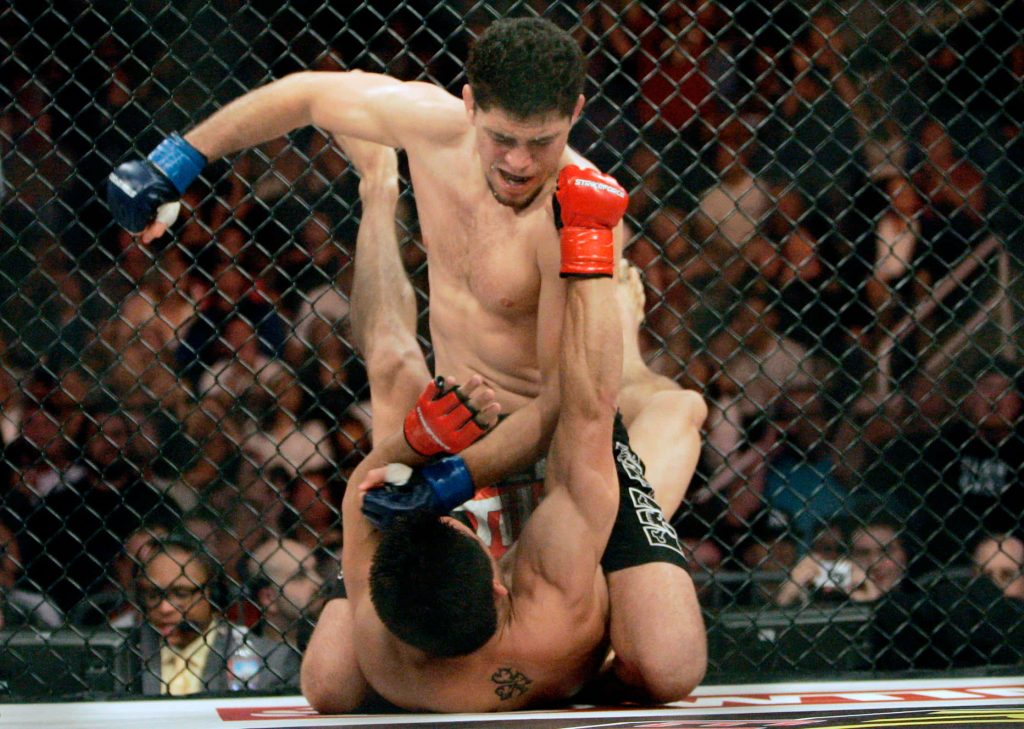 Nick Diaz landing ground and pound strikes against Frank Shamrock in Strikeforce MMA cage fight Wallpaper