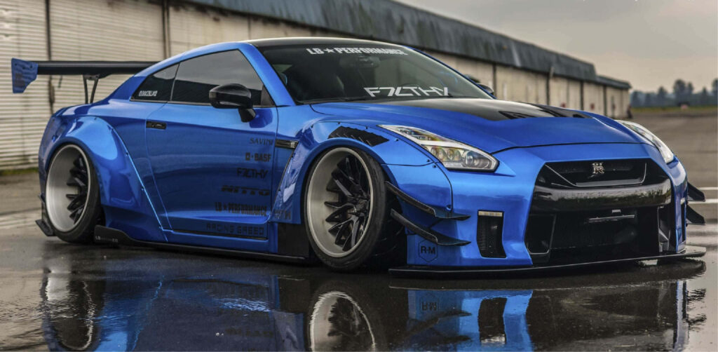 Striking blue Nissan R35 GTR with aggressive body kit on wet surface reflecting bold styling wallpaper