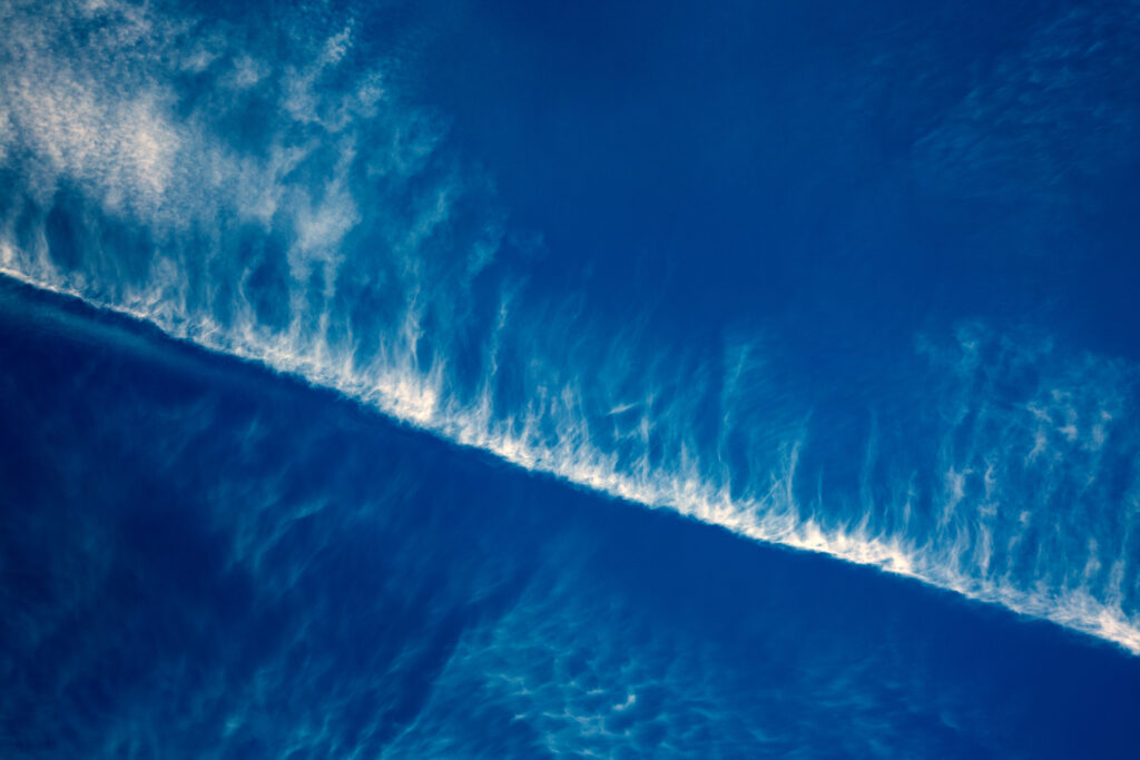Striking blue sky wallpaper with linear white clouds creating dynamic minimalist background