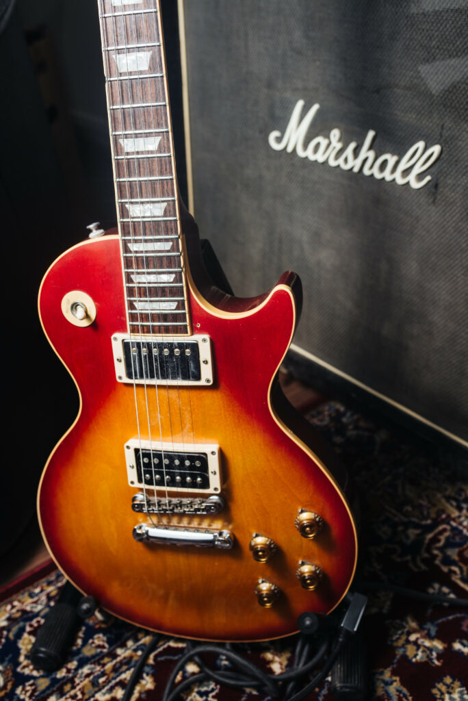 Striking Red Electric Guitar Wallpaper Against Marshall Amplifier