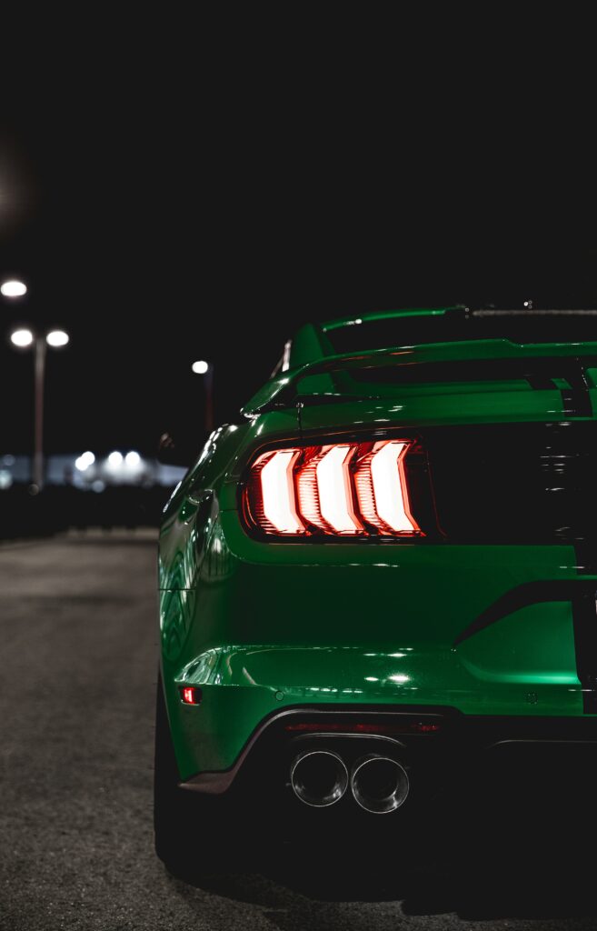 Vibrant Green Car Backview with Glowing Backlights - Nighttime Scene Wallpaper